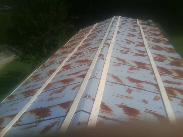 Rusted metal roof panels with new wood purlins before replacement — Storm Damage Roof Repair in Sweetser by Roofing Brothers